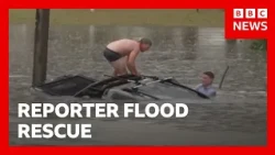 Reporter swims through flood to rescue man from sinking car | BBC News