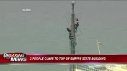 2 people climb to the top of the Empire State Building with apparent message of peace